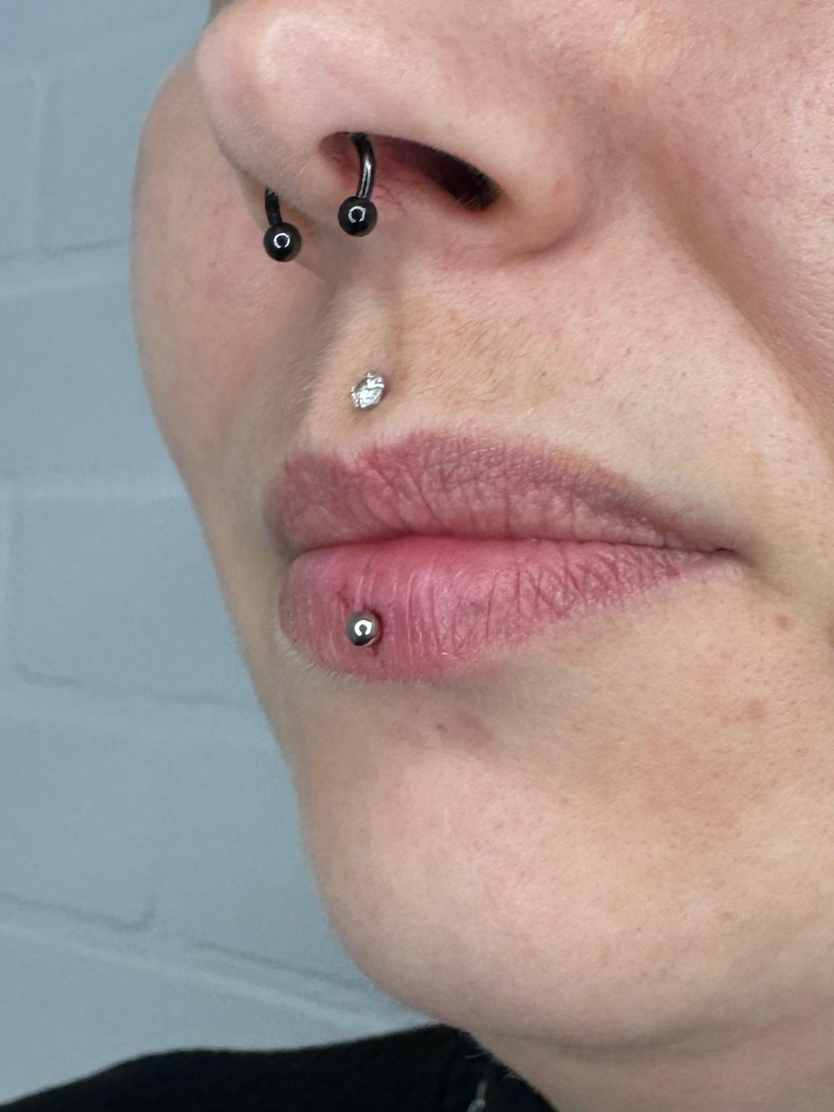 Septum piercing met zwarte ringen